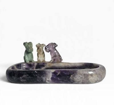 three figurines of animals sitting on top of a stone