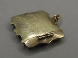 an antique silver locke with a clasp on a gray surface