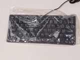 a picture of a computer keyboard wrapped in plastic and sitting on a table