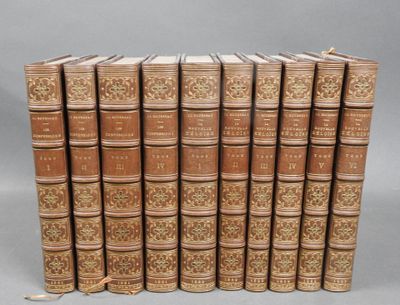 six old books lined up in a row on a gray surface