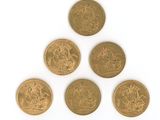 six pièces de six livres sterling disposées en pyramide sur une surface blanche