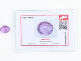 un gros plan sur des pierres précieuses violettes posées sur une surface blanche