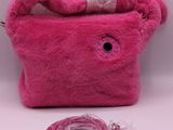 pink purse with a cord attached to it sitting on a white surface