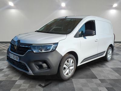 La camionnette blanche est garée dans une pièce au sol carrelé en damier.