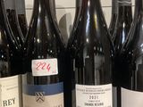 plusieurs bouteilles de vin sont alignées sur une étagère