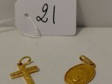 Deux croix en or et une pièce d'or sont posées sur une table