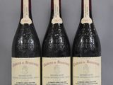 three bottles of wine are lined up on a table