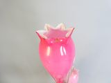 a pink vase that has a flower inside of it
