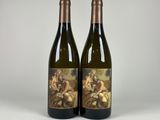two bottles of wine sitting next to each other on a table