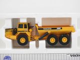 a yellow toy dump truck in a white box