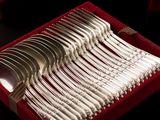 a red box with a bunch of silver spoons in it