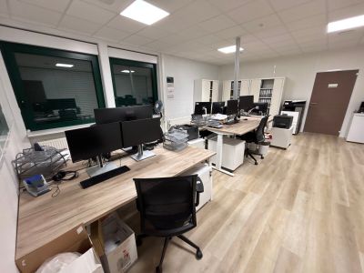 une image représentant un bureau avec de nombreux bureaux et ordinateurs
