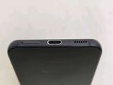 the back of a black cell phone sitting on top of a white table