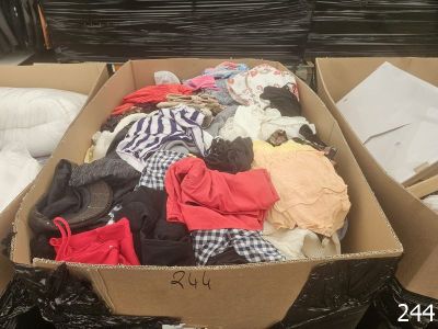 a cardboard box full of clothes on the floor