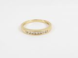 a yellow gold ring with five diamonds on a white background