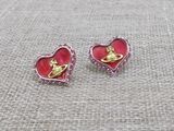 une paire de boucles d'oreilles roses et dorées en forme de cœur, ornées d'un chat