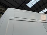 a white van parked inside of a building with a skylight above it