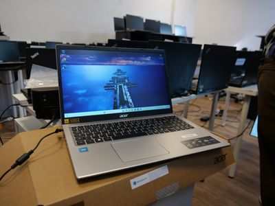 a laptop computer sitting on top of a box in a room