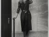 black and white photograph of a woman leaning against a wall