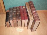 several old books are lined up on the floor in a row