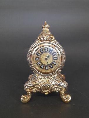 JOPEL. Petite pendule en métal doré à décor de croisillons