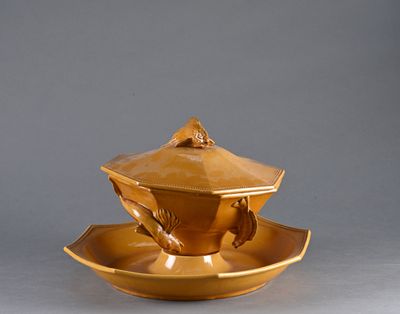 une tasse à thé dorée et sa soucoupe, posées sur une soucoupe