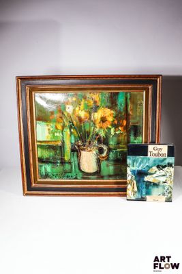 une photo représentant un tableau et un livre posés sur une table
