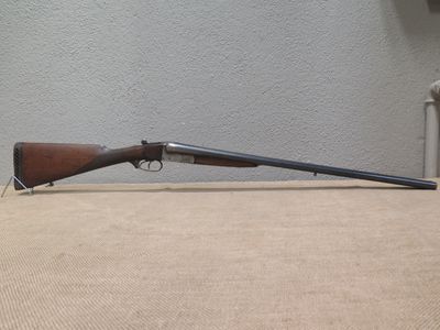 the rifle is laying on the table next to the wall
