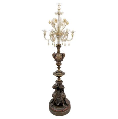 un grand lustre en bronze et en verre orné de fleurs, posé sur un socle