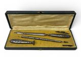 a set of three silverware items in a case on a white background