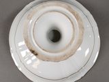 a white plate with a brown rim on a gray surface