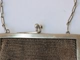 silver metal mesh purse with chain strap on white background