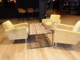 several chairs and a table in a room with a bar in the background