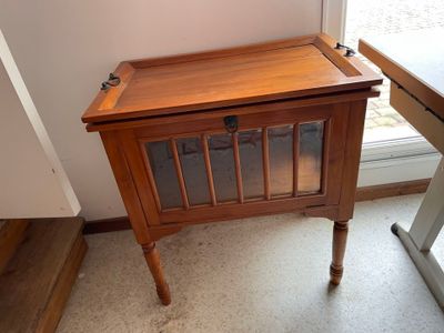 a small wooden table with a glass door on it