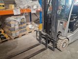 a forklift in a warehouse with pallets and boxes