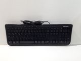 un clavier et une souris noirs posés sur une surface blanche