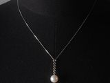 un gros plan sur un mannequin portant un collier orné d'une perle
