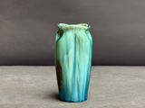 un vase bleu et vert posé sur une table