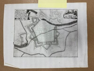 une vieille carte d'une ville, posée sur un morceau de papier, sur une table