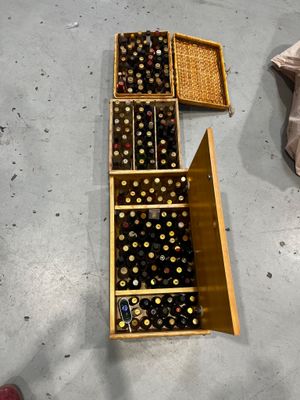 bottles of wine sit in a wooden crate on the floor