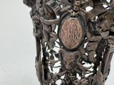 a silver vase with a design on it on a table
