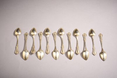 six silver spoons are lined up in a row on a white surface