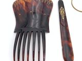 a hair comb and a pair of scissors next to a pair of scissors