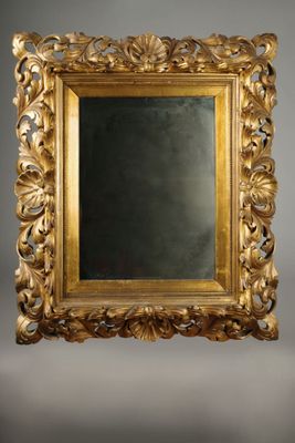 un miroir orné d'un cadre doré sur fond gris