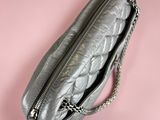 a close up of a silver purse on a pink background