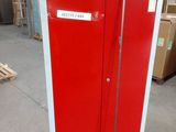 a red cabinet with a sign on it in a warehouse