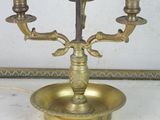 a brass candelab with three candles on top of it