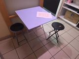 une table violette et deux tabourets dans la cuisine