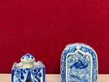two small blue and white ceramic objects on a table