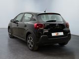 the rear of a black car is parked in a large room